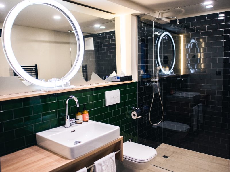 Salle de bains rénovée par K'RENOV avec carrelage métro vert, douche à l'italienne carrelée en noir et plafond peint